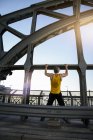 Mann macht Klimmzüge auf Brücke, München, Bayern, Deutschland — Stockfoto