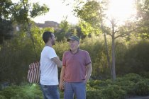 Homem adulto médio conversando com homem sênior no parque — Fotografia de Stock