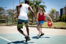 Jóvenes practicando baloncesto en cancha de baloncesto - foto de stock