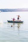 Amigos saltando de barco e nadando no lago, Schondorf, Ammersee, Baviera, Alemanha — Fotografia de Stock