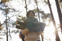 Frau sammelt Baumstämme für Lagerfeuer im Wald — Stockfoto