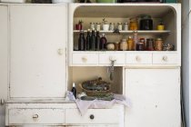 Jars and bottles of home-made food on retro style kitchen cabinet — Stock Photo
