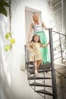 Mãe e filha andando escada espiral de metal — Fotografia de Stock