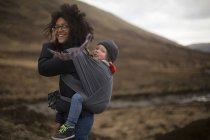 Mãe carregando filho em funda — Fotografia de Stock