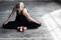 Танцовщица растягивается в студии на полу — стоковое фото