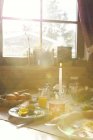 Close up de mesa de café da manhã iluminado pelo sol na cabine log — Fotografia de Stock