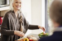 Seniorin bereitet Essen in Küche zu — Stockfoto