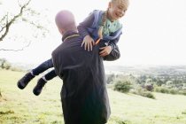 Padre llevando a su hija en brazos - foto de stock