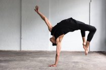 Dancer practicing in studio, bending over backwards — Stock Photo