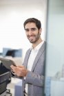 Молодий чоловік тримає цифровий планшет в офісі — стокове фото