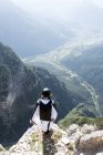 Male BASE jumper in wingsuit standing on edge of mountain, Dolomites, Italy — Stock Photo