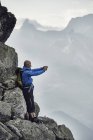 Зрелый мужчина на скалах, фотографирующийся, Вале, Швейцария — стоковое фото