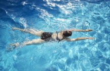Overhead view of mature woman  swimming in swimming pool — Stock Photo