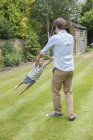 Pai e filho brincando juntos no jardim — Fotografia de Stock