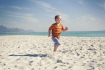 Мальчик бегает по пляжу, Кейптаун, Западный Кейп, Южная Африка — стоковое фото