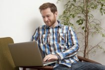 Чоловічий клієнт друкує на ноутбуці в стилі кафе — стокове фото