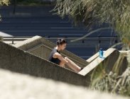 Giovane donna che si estende su gradini — Foto stock