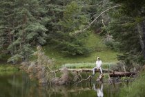 Мужчина на упавшем дереве рядом с озером Вад-де-Аран, Испания — стоковое фото
