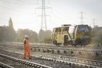 Железнодорожный рабочий сигнализирует обслуживающему поезду в Лафборо, Англия, Великобритания — стоковое фото