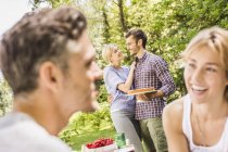 Group of male and female friends at garden party — Stock Photo
