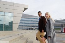 Businessman and businesswoman, walking up steps together — Stock Photo
