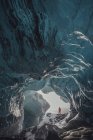 Uomo in piedi all'ingresso della grotta di ghiaccio, Ghiacciaio Vatnajokull, Parco Nazionale Vatnajokull, Islanda — Foto stock