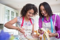 Mother and grown daughter, cooking in kitchen — Stock Photo