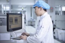 Чоловік-працівник використовує комп'ютер на високотехнологічній фабриці — стокове фото