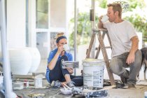Couple painting home together drinking coffee — Stock Photo
