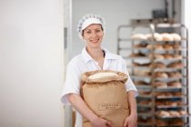 Chef carrying sack of flour in kitchen — Stock Photo