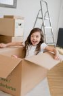 Smiling girl playing in cardboard box — Stock Photo