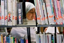 Donna che legge in biblioteca — Foto stock