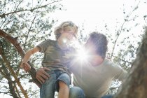 Father and son climbing tree — Stock Photo