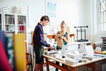 Young craftswoman and man in creative print studio — Stock Photo