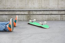 Füße von Teenager, der vom Skateboard gefallen ist — Stockfoto