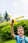 Хлопчик грає з іграшковим літаком на відкритому повітрі — стокове фото