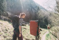 Adult friends with bouldering mat backpack walking along rural path, Lombardy, Italy — Stock Photo