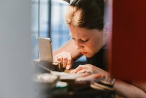 Female jeweller engraving metal at workbench — Stock Photo