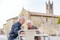 Tourist couple looking at smartphone at sidewalk cafe, Siena, Tuscany, Italy — Stock Photo