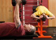Mann stemmt Gewichte im Fitnessstudio — Stockfoto