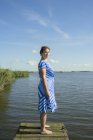Mujer posando en el distrito de los lagos de Frisia en vestido vintage, Sneek, Frisia, Países Bajos - foto de stock