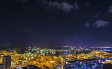 Paisaje urbano con vista lejana de la terminal de contenedores en la noche, Singapur, Sudeste Asiático - foto de stock