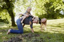 Madre e hijas disfrutando del parque - foto de stock