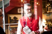 Quirky homem com jornais esportivos em bar e restaurante, Bournemouth, Inglaterra — Fotografia de Stock