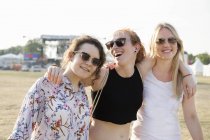 Portrait of three female friends at festival — Stock Photo