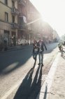 Счастливая пара, прогуливающаяся по освещенной солнцем улице — стоковое фото