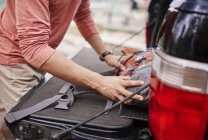 Cropped view of man putting rucksack in car boot, Cracovie, Malopolskie, Pologne, Europe — Photo de stock