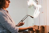 Female jeweller using flaming  blow torch at workbench — Stock Photo