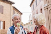 Tourist couple eating ice cream cones in Siena, Tuscany, Italy — Stock Photo
