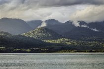 Brume montant des montagnes au-dessus du lac Vert, Parc national du Queulat, Chili — Photo de stock
